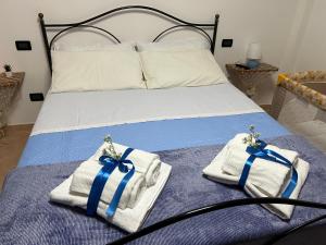 ein Bett mit Handtüchern und blauen Bögen darauf in der Unterkunft Casa vacanze Bella Vista in Campomarino