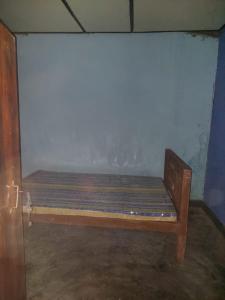 a wooden bench in a room with a wall at House near main temple in Batticaloa