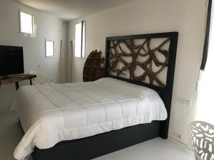 LA MAISON BLANCHE IBIZA 5* في مدينة إيبيزا: غرفة نوم فيها سرير وتلفزيون
