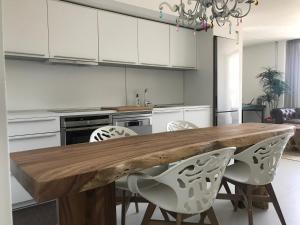 una cucina con tavolo in legno e armadietti bianchi di LA MAISON BLANCHE IBIZA 5* a Ibiza Città