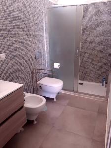 a bathroom with a toilet and a sink and a shower at Il Giardino dei Coralli in Plemmirio