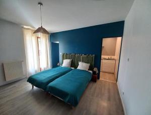 una camera da letto blu con un letto e una parete blu di Gîte du Solnan a Villemotier