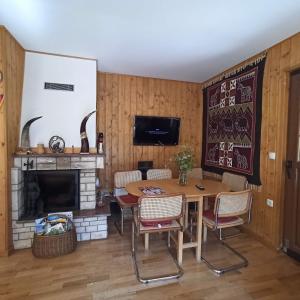 comedor con mesa y chimenea en Abgeschiedene Berghütte mit 6 Schlafzimmern, umgeben von einem Pinienwald, en Rudanovac
