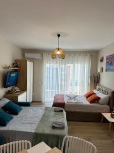 a living room with two beds and a television at Sea La Vie in Shëngjin