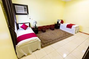a bedroom with two beds and a rug at العييري للشقق 014 يومي وشهري بالمدينة in Al Madinah