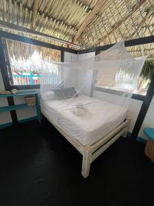 a bedroom with a bed with a mosquito net at Palenque Beach House in San Onofre