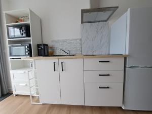 una cucina con armadietti bianchi e frigorifero bianco di Studio Pleuven a Pleuven