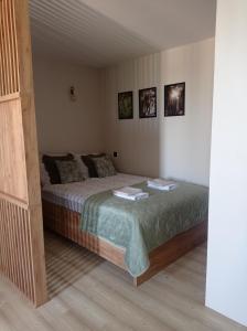 1 dormitorio con 1 cama con 2 toallas en Czwarte Piętro, en Zamość