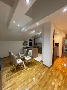 Un comedor y una cocina con mesa y sillas. en Casa Mia Apartments - Modern - Comfortable Stays 5 Min from Airport - Transport Possible, en Ledine