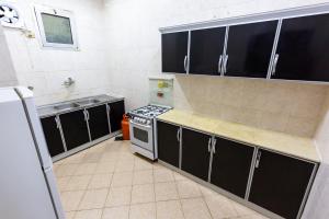 a kitchen with black cabinets and a stove at العييري للشقق 014 يومي وشهري بالمدينة in Al Madinah