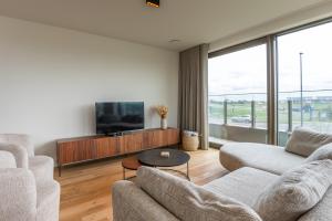 a living room with two couches and a flat screen tv at New apartment on a marvelous location in Ostend