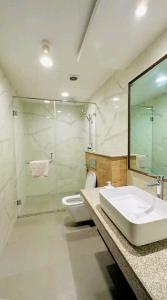 y baño con lavabo, aseo y ducha. en Premium 1BR DHA Phase 5 en Lahore