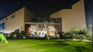 un gran edificio con un césped verde delante de él en Premium 1BR DHA Phase 5 en Lahore
