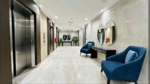 korytarz z niebieskimi krzesłami, biurkiem i lustrem w obiekcie Premium 1BR DHA Phase 5 w mieście Lahaur