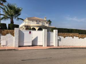 Ein weißer Zaun mit einem Haus dahinter. in der Unterkunft Maison type villa 4 façades 4 bedrooms in Gran Alacant