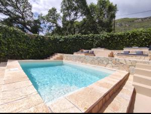 a swimming pool in a yard with a stone wall at GKK House private swimming pool luxury house in Skriperón