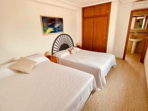 ein Hotelzimmer mit zwei Betten und einer Kerze auf dem Bett in der Unterkunft Maison type villa 4 façades 4 bedrooms in Gran Alacant + 9 Fotos