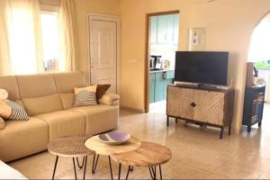 ein Wohnzimmer mit Couch und Flachbildfernseher in der Unterkunft Maison type villa 4 façades 4 bedrooms in Gran Alacant