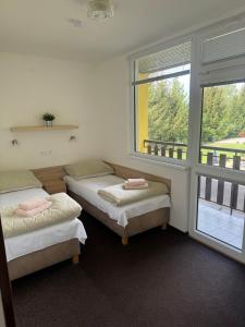 two beds in a room with two windows at Hotel Formule in Děčín