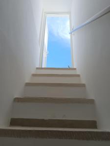 a stairway with a door in a white building at La Finestra su Santa Lucia in Monopoli
