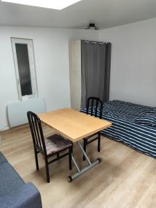 uma mesa e duas cadeiras num quarto com uma cama em studio independant avec jardin au calme em Neuilly-Plaisance