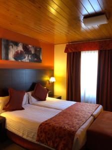 a hotel room with a large bed with a window at Hotel Solineu in La Molina