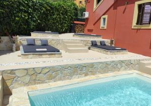 uma piscina com duas espreguiçadeiras ao lado de um edifício em GKK House private swimming pool luxury house em Skriperón