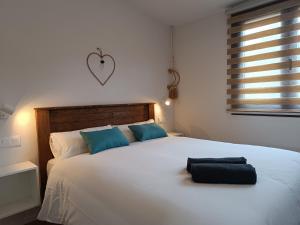 sypialnia z dużym białym łóżkiem z niebieskimi poduszkami w obiekcie Casas Natura Suites w mieście Graus