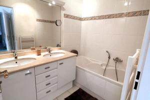 a white bathroom with two sinks and a bath tub at Charmante villa avec piscine - Golfe St Tropez in La Croix-Valmer +8 photos
