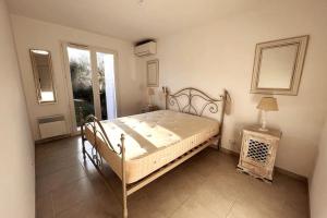 a bedroom with a bed and a table and a window at Charmante villa avec piscine - Golfe St Tropez in La Croix-Valmer