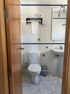 uma casa de banho com um WC e um lavatório em APARTAHOTEL DOÑA REYES em Chipiona