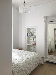 a white bedroom with a bed and a mirror at Casa verde in Ventimiglia