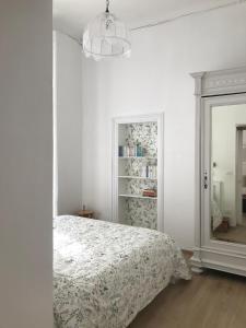a white bedroom with a bed and a mirror at Casa verde in Ventimiglia +15 photos