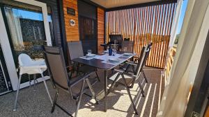une table et des chaises sur le balcon d'une maison dans l'établissement CHARTA mobile home Bimbo, à Pirovac