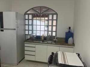 a kitchen with a sink and a refrigerator at Casa 400m do shopping in Governador Valadares