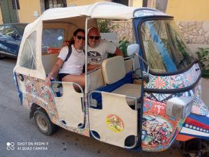 a man and woman sitting in a golf cart at La dimora degli scrittori in Porto Empedocle