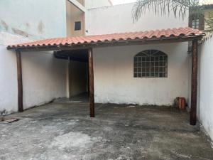 eine Garage mit rotem Dach an der Gebäudeseite in der Unterkunft Casa 400m do shopping in Governador Valadares