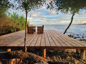 a wooden dock with two chairs on the water at Surf Deck in Thulusdhoo