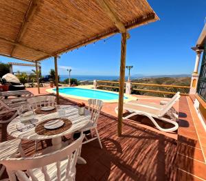 taras ze stołem i krzesłami oraz basenem w obiekcie Casa Nuestro Sueño, fantastic sea views w mieście Torrox
