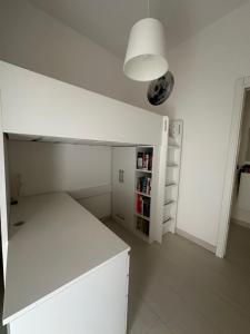 une cuisine blanche avec un comptoir blanc et une étagère dans l'établissement Perla Marina, à Pescara