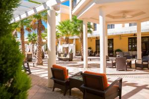 un patio con sillas, mesas y palmeras en Charleston Marriott en Charleston