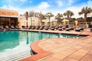 a swimming pool with lounge chairs in a resort at Charleston Marriott in Charleston