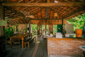 an outdoor kitchen with a table and a refrigerator at Paraty Paradiso in Parati-Mirim