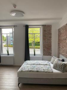 sypialnia z łóżkiem i 2 oknami w obiekcie Appartementhaus EMDEN w mieście Emden
