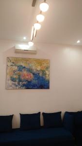 Mountain View في مراكش: أريكة زرقاء في غرفة مع لوحة على الحائط