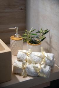 - une pile de serviettes avec un bow sur un comptoir de salle de bains dans l'établissement Elenas Home - Dream & Love apts w Private pool, à Alikianós