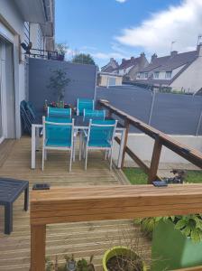 een patio met blauwe stoelen en een tafel op een terras bij CHEZ ISA Maison à 2 km de la plage de Le Portel 62 in Outreau