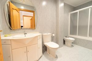 y baño con aseo, lavabo y espejo. en Bonbillo - ONGI ETORRI, en Zumaia