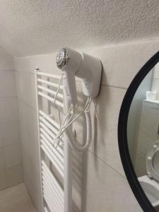 a blow dryer on the wall of a bathroom at Apartmani Jelenača in Sinanovići +10 photos