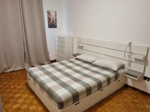 a bedroom with a bed with a checkeredkered blanket at Apt by Trieste University in Trieste